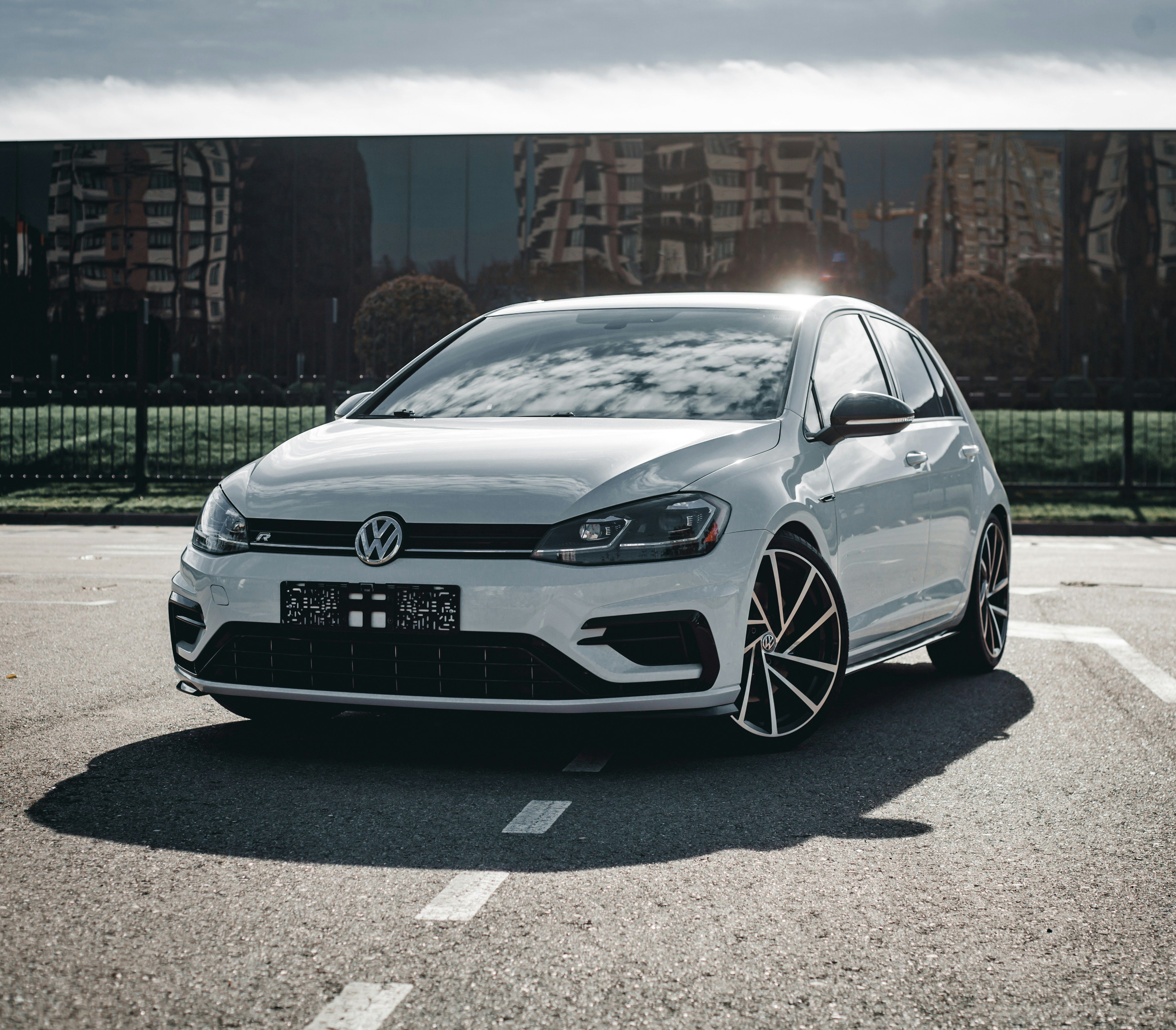 Hvit Volkswagen Golf R parkert foran en glassfasade